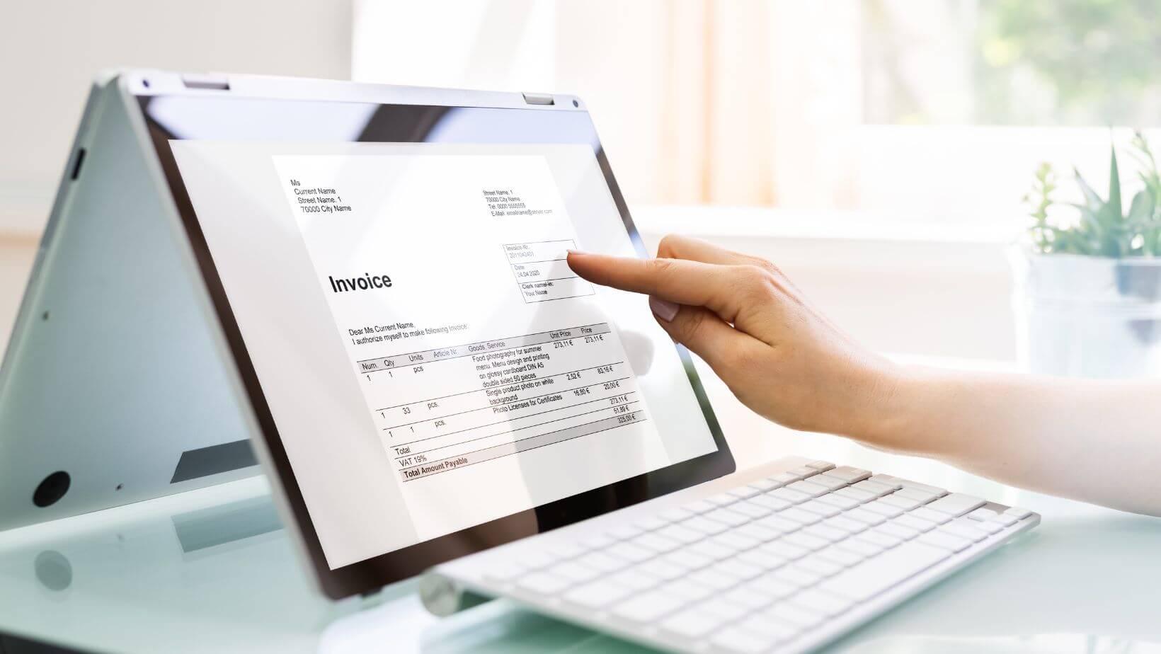 Hand tippt auf Tablet, Aufschrift Invoice, Rechnungen digitalisieren