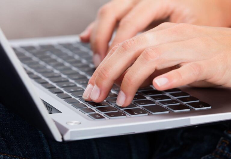 manos escribiendo en el teclado de un portátil